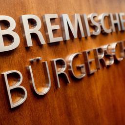 Ein Schriftzug hängt an einem Rednerpult im Plenarsaal der Bremischen Bürgerschaft. 