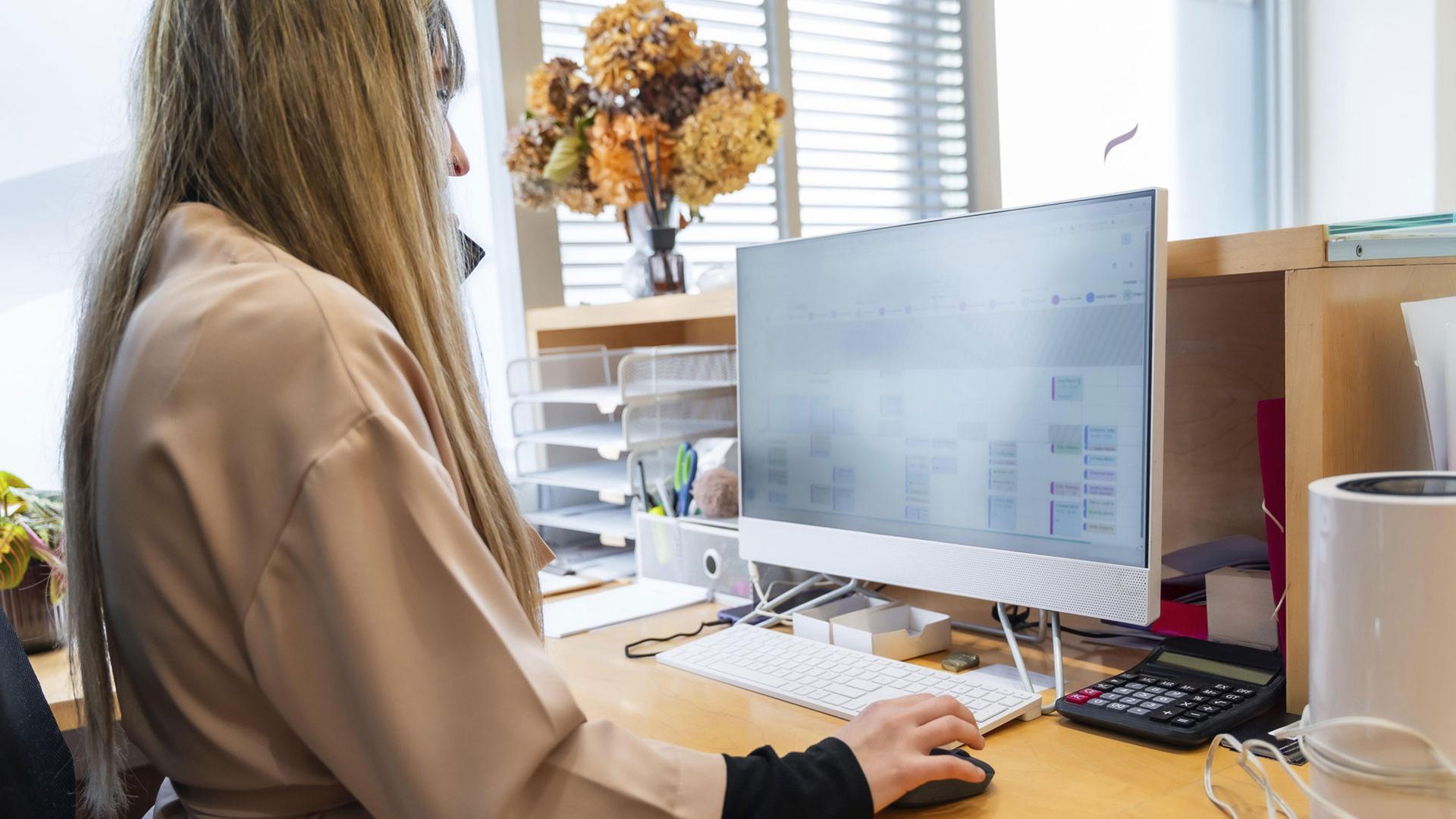 Eine Mitarbeiterin verwaltet auf einem Computersystem Patientendaten. | picture alliance / imageBROKER