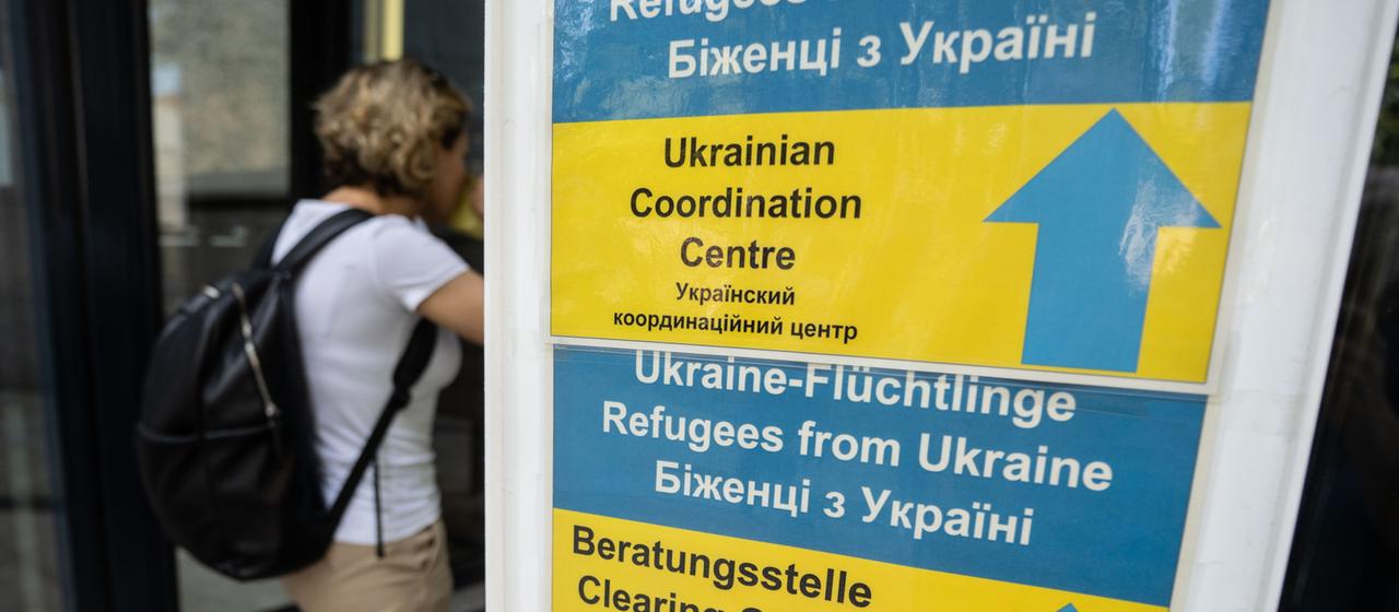 Ein Schild, das ukrainischen Flüchtlingen den Weg zu Beratungsangeboten weist