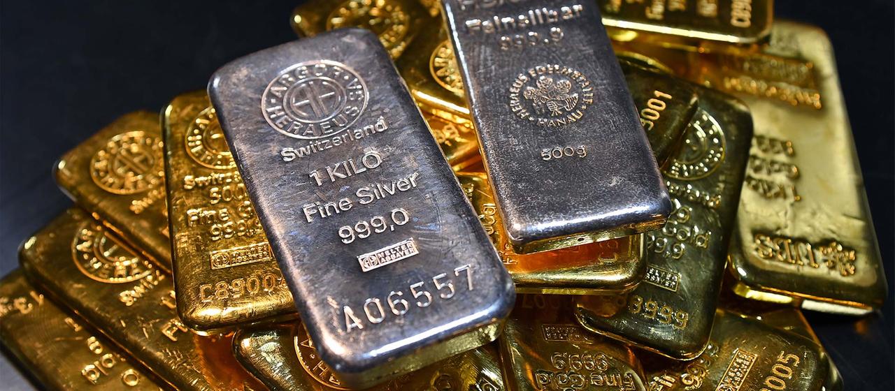 Silberbarren liegen auf Goldbarren.