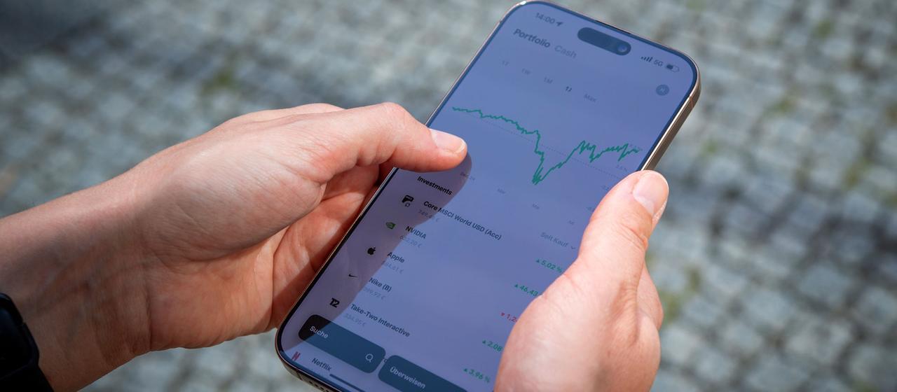 Eine Person handelt Aktien auf einem Smartphone.