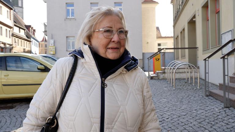Eine Frau steht auf einem Parkplatz.