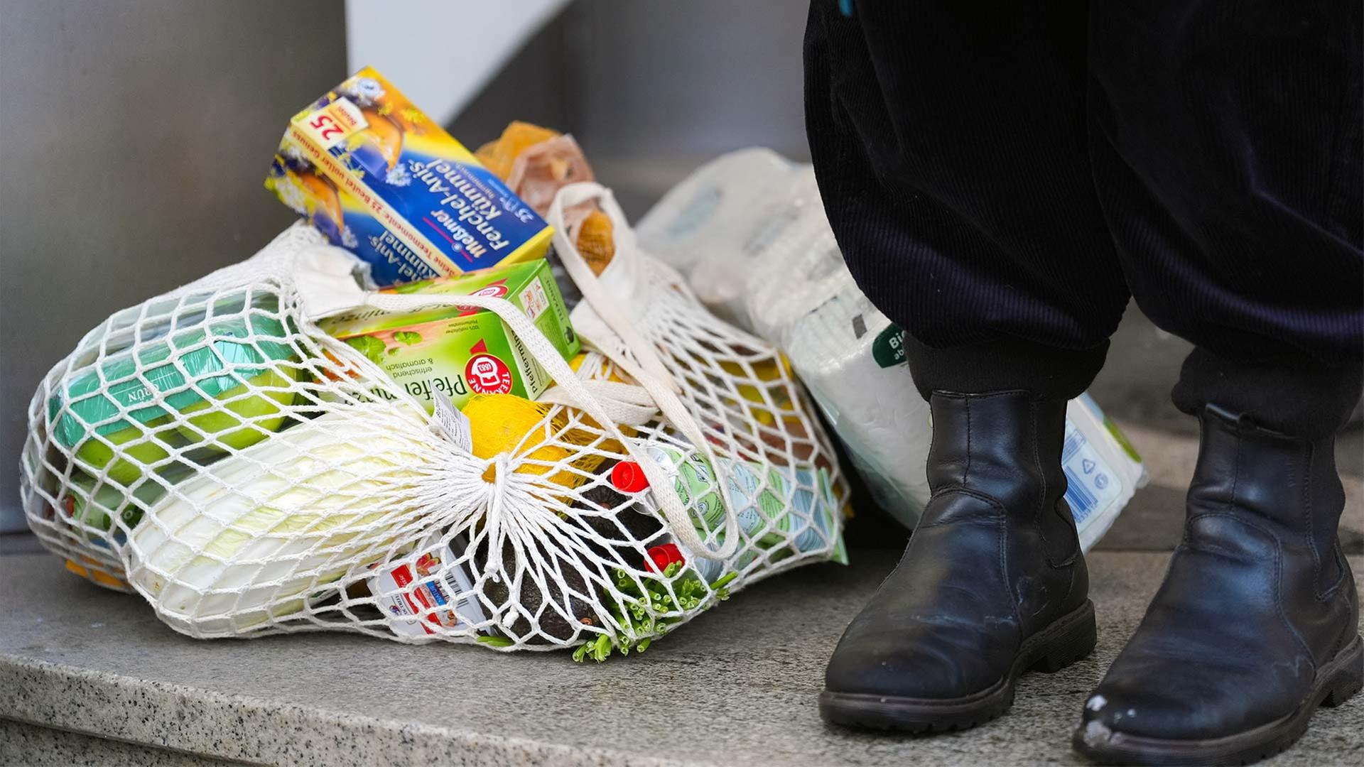 Eine Person steht neben ihren EinkÃ¤ufen vor einem Supermarkt. | picture alliance/dpa