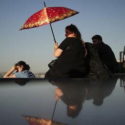 Eine Frau schützt sich an einem heißen Sommertag in Istanbul mit einem Schirm vor der Sonne.