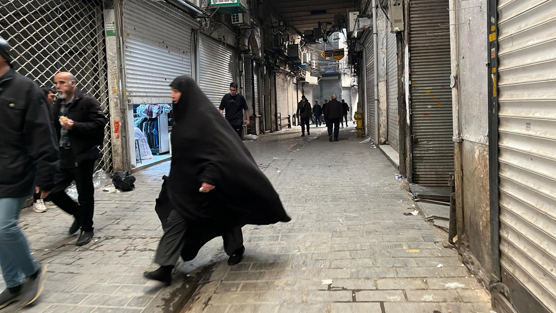 Menschen gehen in Teherans Hauptbasar an geschlossenen Geschäften vorbei | dpa