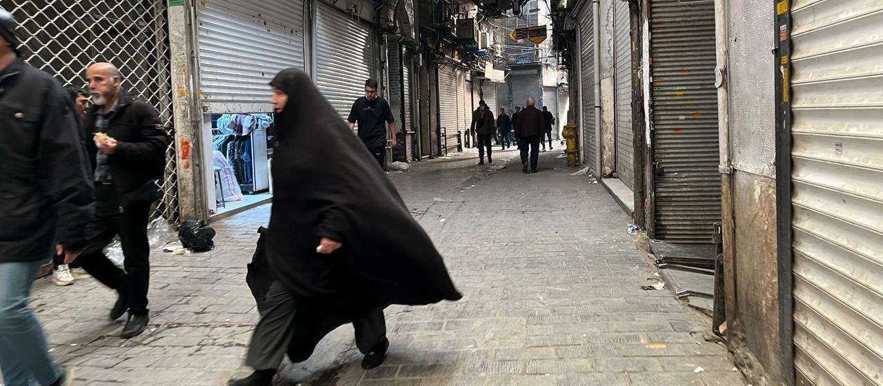 Menschen gehen in Teherans Hauptbasar an geschlossenen Geschäften vorbei
