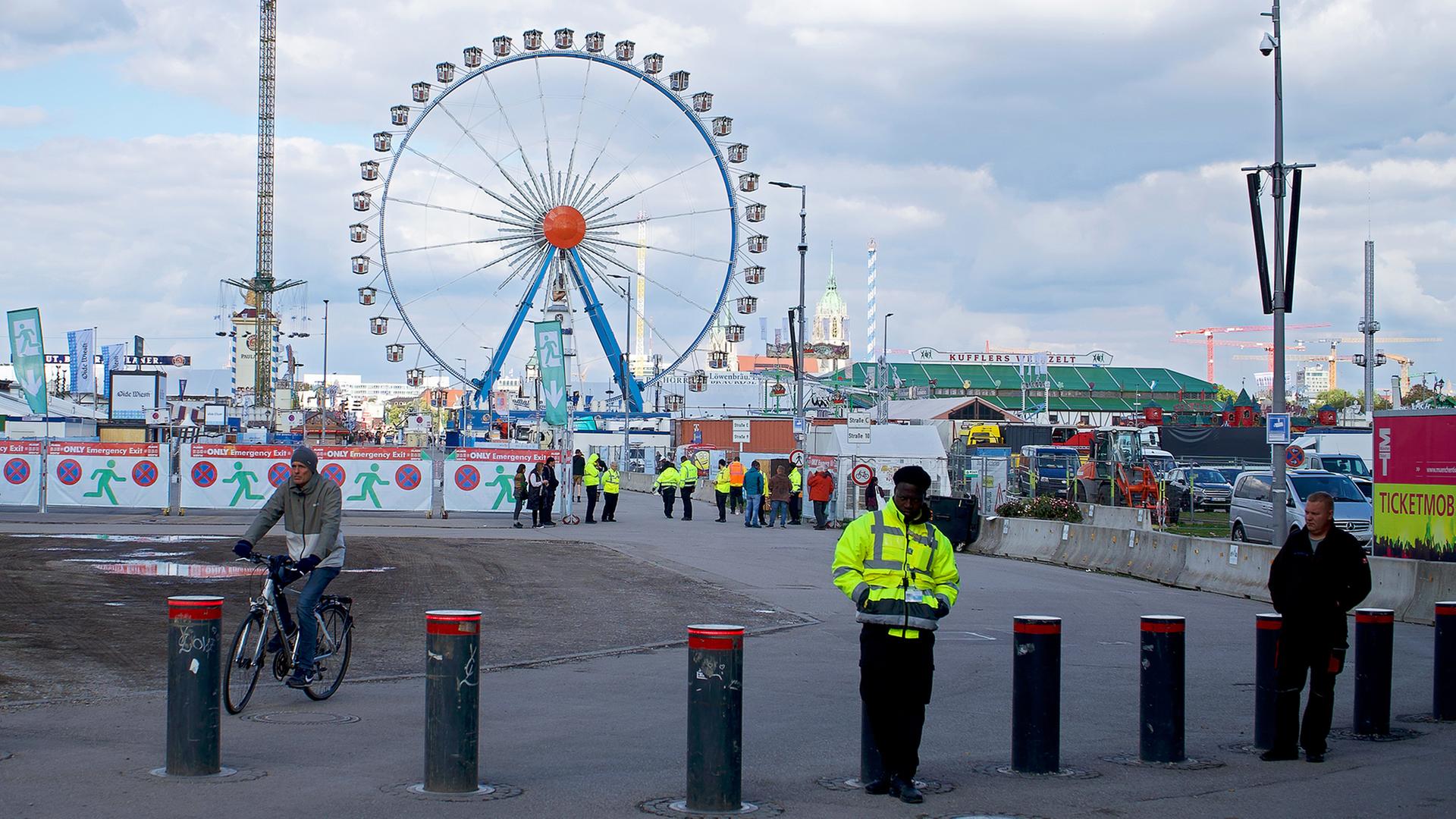 Mitarbeiter einer Sicherheitsfirma bewachen den Zugang zum Oktoberfest. | dpa