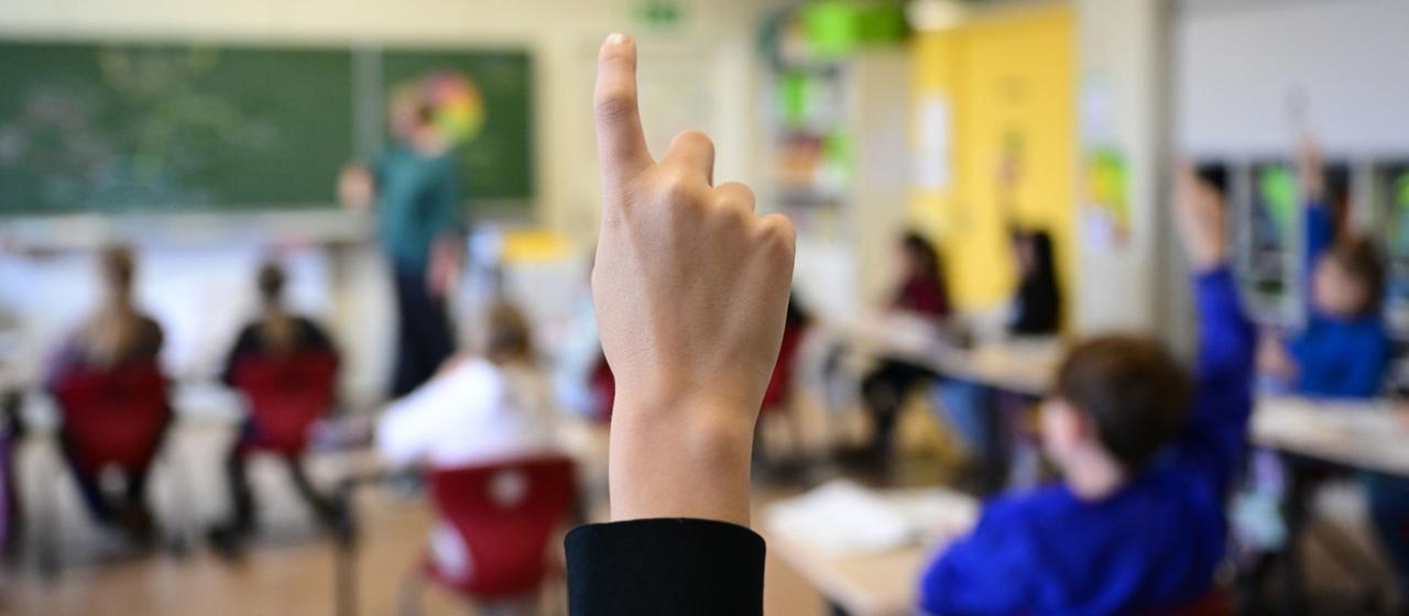 Ein Schüler meldet sich in einem Klassenzimmer. (Archiv)