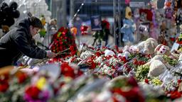 Menschen legen Blumen vor der Crocus City Hall in Moskau nieder.