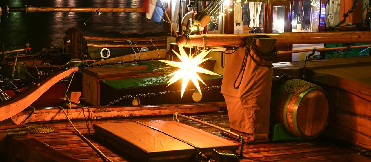 Ein Weihnachtsstern leuchtet an Bord eines alten Segelschiffes.