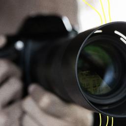 Ein Mann mit Kamera und Teleobjektiv.