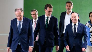 Stephan Weil, Hendrik Wüst und Olaf Scholz im Vordergrund einer Gruppe kommen zur Pressekonferenz zum Bund-Länder-Gipfel