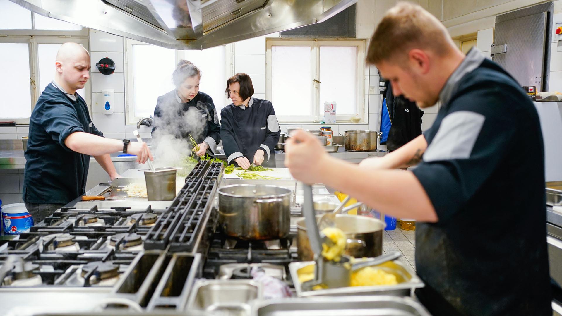 Aus der Ukraine stammende Menschen arbeiten in einer Küche in einer Pfälzer Gaststätte. | picture alliance/dpa
