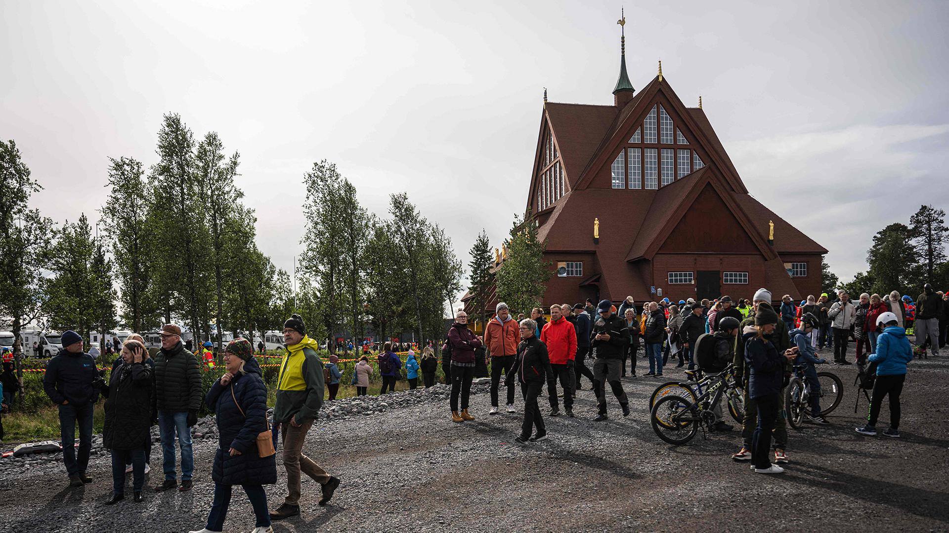 Menschen gehen an der hölzernen Kiruna-Kirche vorbei. | AFP