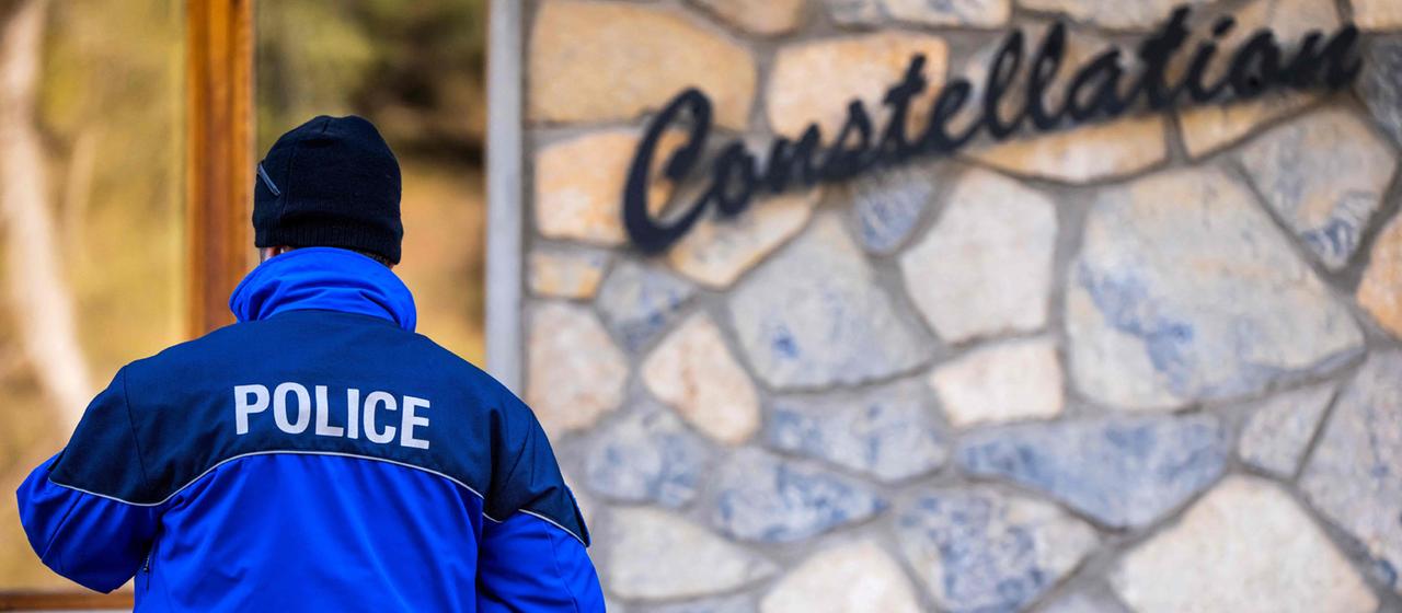 Ein Polizist steht nach einem Feuer vor der Bar Le Constellation in Crans-Montana