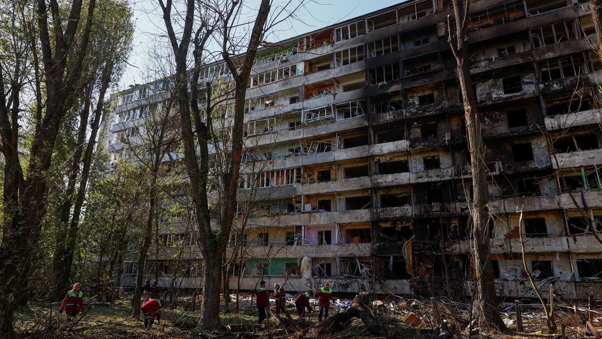 Ukrainische Rettungskräfte sind an einem zerstörten Wohnhaus in Kiew im Einsatz. | REUTERS