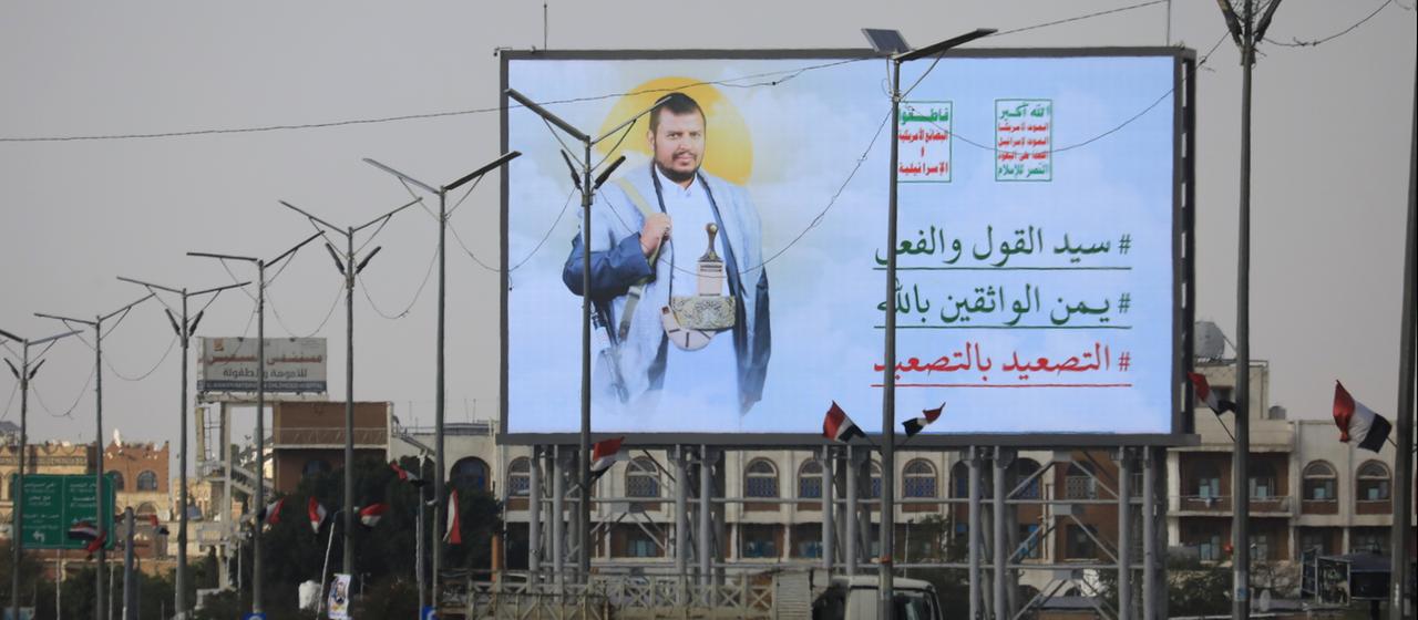 Autos fahren an einer Anzeigentafel vorbei, die Huthi-Anführer Abdul-Malik al-Huthi zeigt.