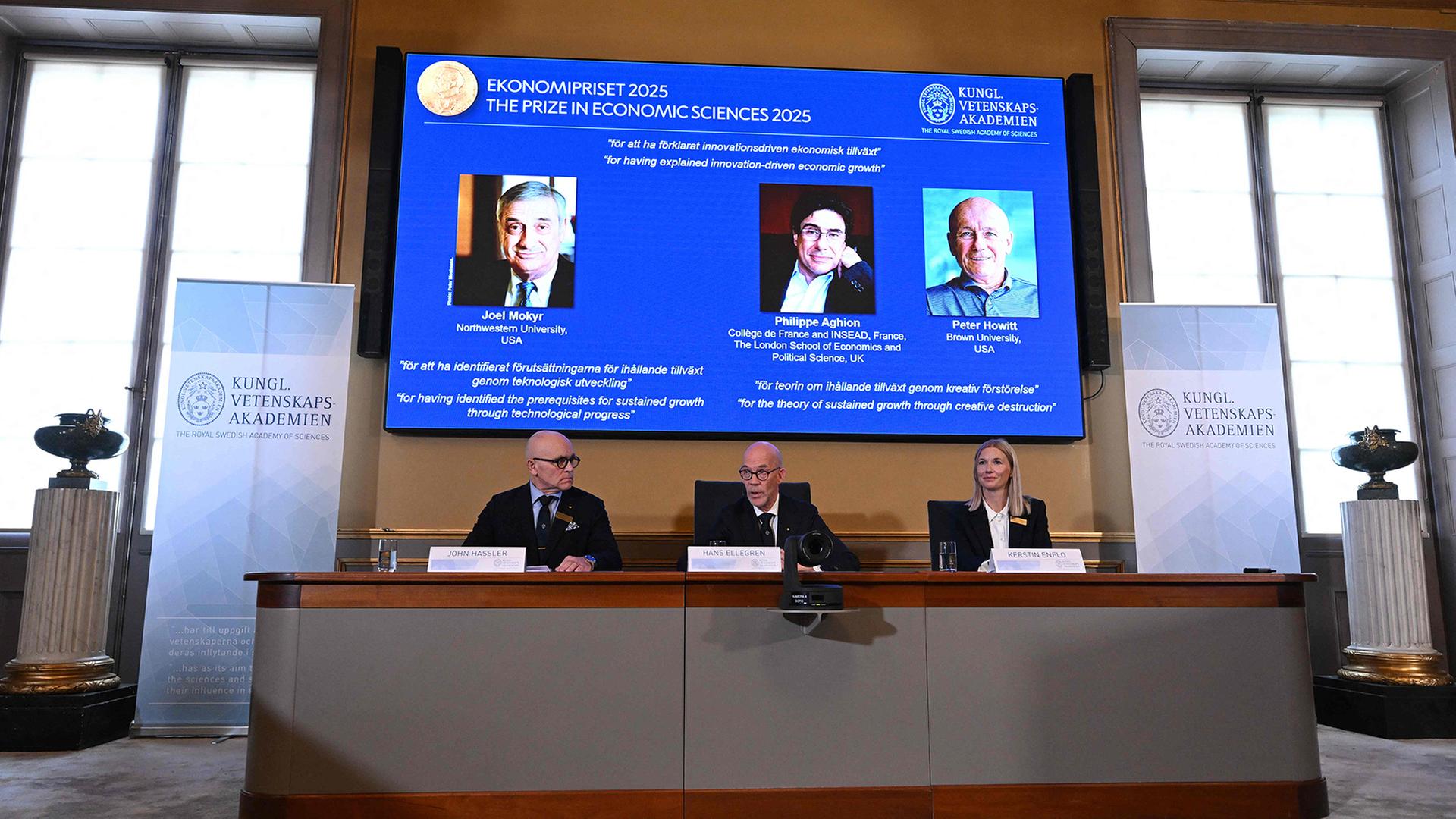 Bilder von Joel Mokyr, Philippe Aghion und Peter Howitt sind auf einem Bildschirm zu sehen. | Niklas Elmehed / Nobel Prize Outreach