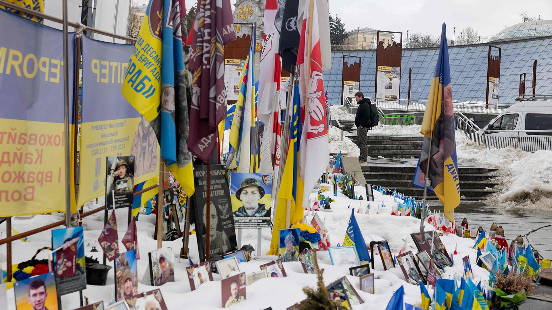 Ein Anwohner besucht eine provisorische Gedenkstätte für ukrainische und ausländische Soldaten auf dem Unabhängigkeitsplatz in Kiew. | AFP