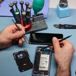 Ein Techniker arbeitet an einem Smartphone mit defektem Display in seinem kleinen Fachgeschäft für Reparaturen und Zubehör. (Quelle: dpa/Christian Charisius)