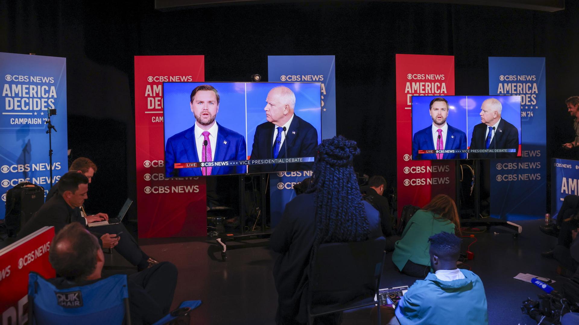 Menschen verfolgen das TV-Duell zwischen JD Vance und Tim Waltz.