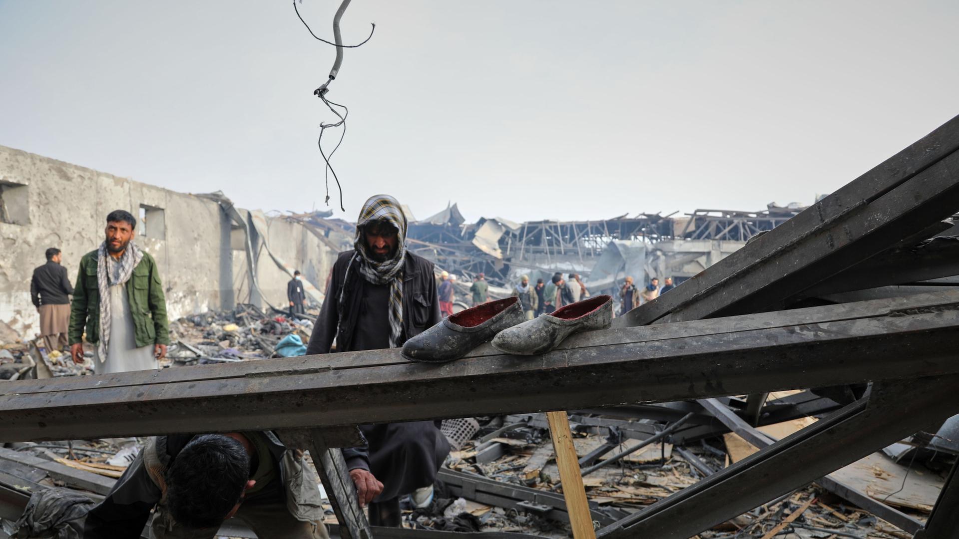 Anwohner und Freiwillige inspizieren den Ort eines Luftangriffs auf eine Klinik in der afghanischen Hauptstadt. | Siddiqullah Alizai/AP/dpa