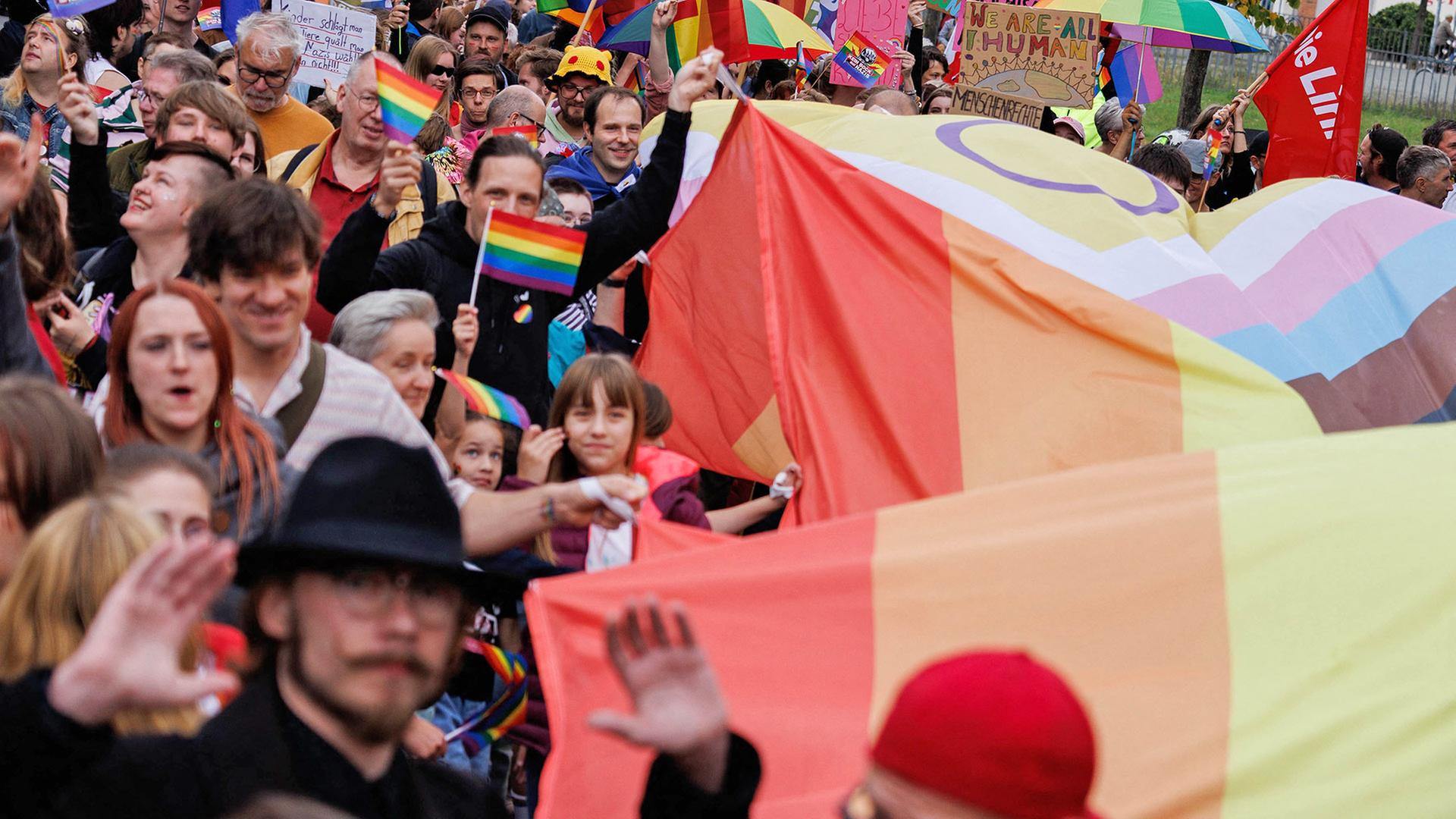 Teilnehmer des Christopher Street Days (CSD) in Hennigsdorf, Brandenburg, tragen eine große Regenbogenfahne. (Quelle: Picture Alliance/Carsten Koall) | Picture Alliance/Carsten Koall