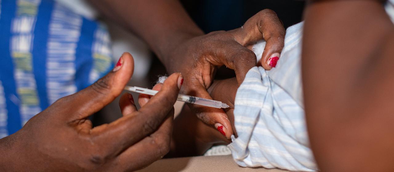 Eine Krankenschwester impft ein Kind gegen Malaria.