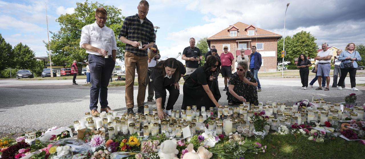 Menschen legen Blumen und Kerzen an einem improvisierten Denkmal vor einer Schule in Fagersta, Schweden, nieder.
