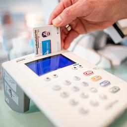 Eine Versichertenkarte wird in ein Lesegerät gesteckt.