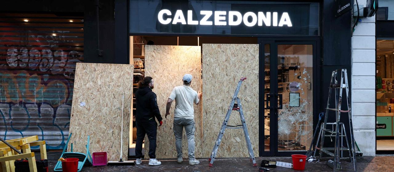 Handwerker sichern ein eingeschlagenen Schaufenster in Lille