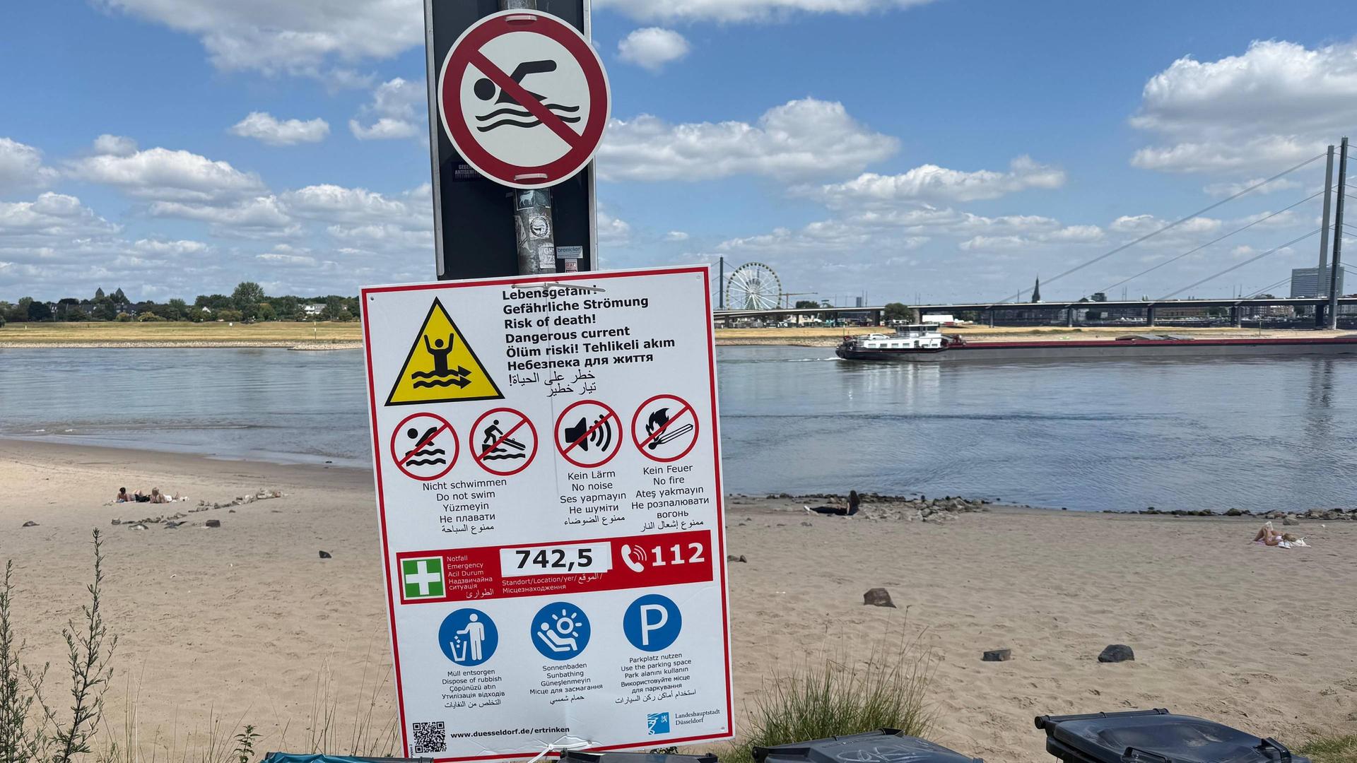 Schilder weisen in verschiedenen Sprachen auf die Gefahren im Rhein hin. | WDR/Joel Bamiselu
