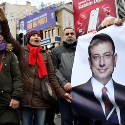 Menschen halten bei einem Protest in Istanbul gegen die Festnahme von Ekrem Imamoğlu ein Plakat mit seinem Bild.