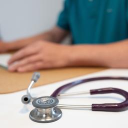 Ein Stethoskop liegt auf dem Tisch einer Arztpraxis.