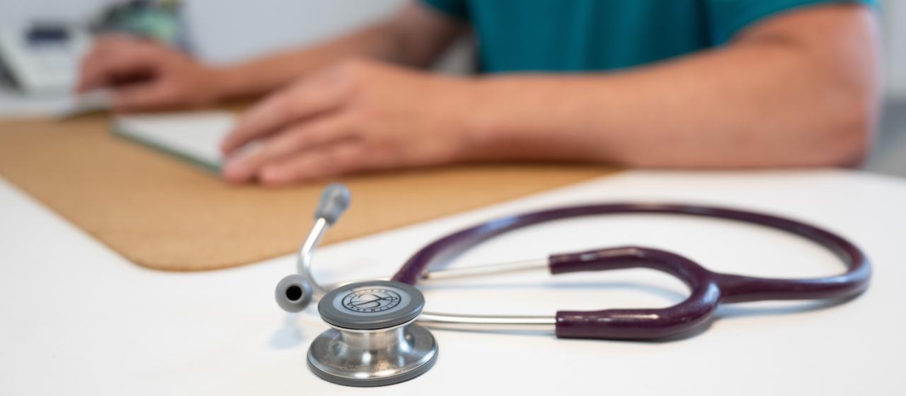 Ein Stethoskop liegt auf dem Tisch einer Arztpraxis.