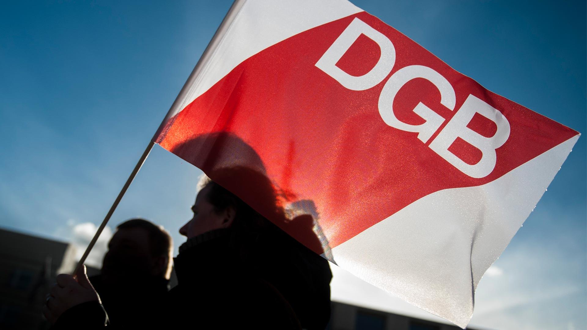 Eine Fahne des Deutschen Gewerkschaftsbundes (DGB) wird von einer Frau gehalten. | picture alliance / photothek