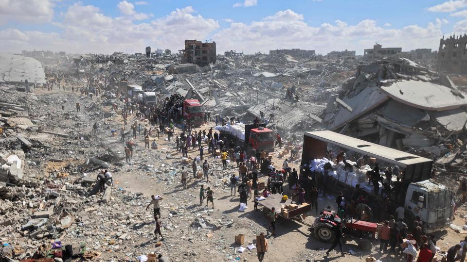 Menschen stehen im Gazastreifen zwischen Trümmern um Hilfslieferungen an