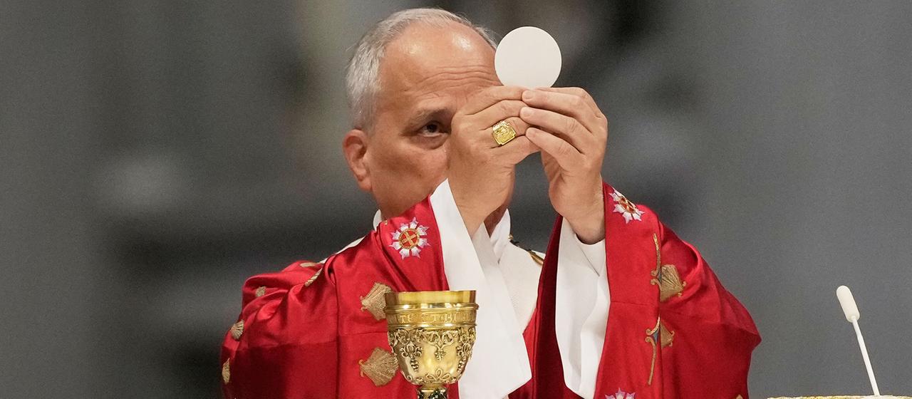 Papst Leo XIV. hält die Hostie während der Pfingstmesse im Petersdom im Vatikan hoch.