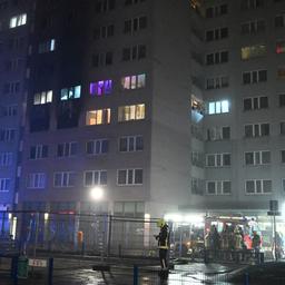 Feuerwehrleute stehen für Löscharbeiten vor einem Wohnhaus in Berlin-Friedrichsfelde