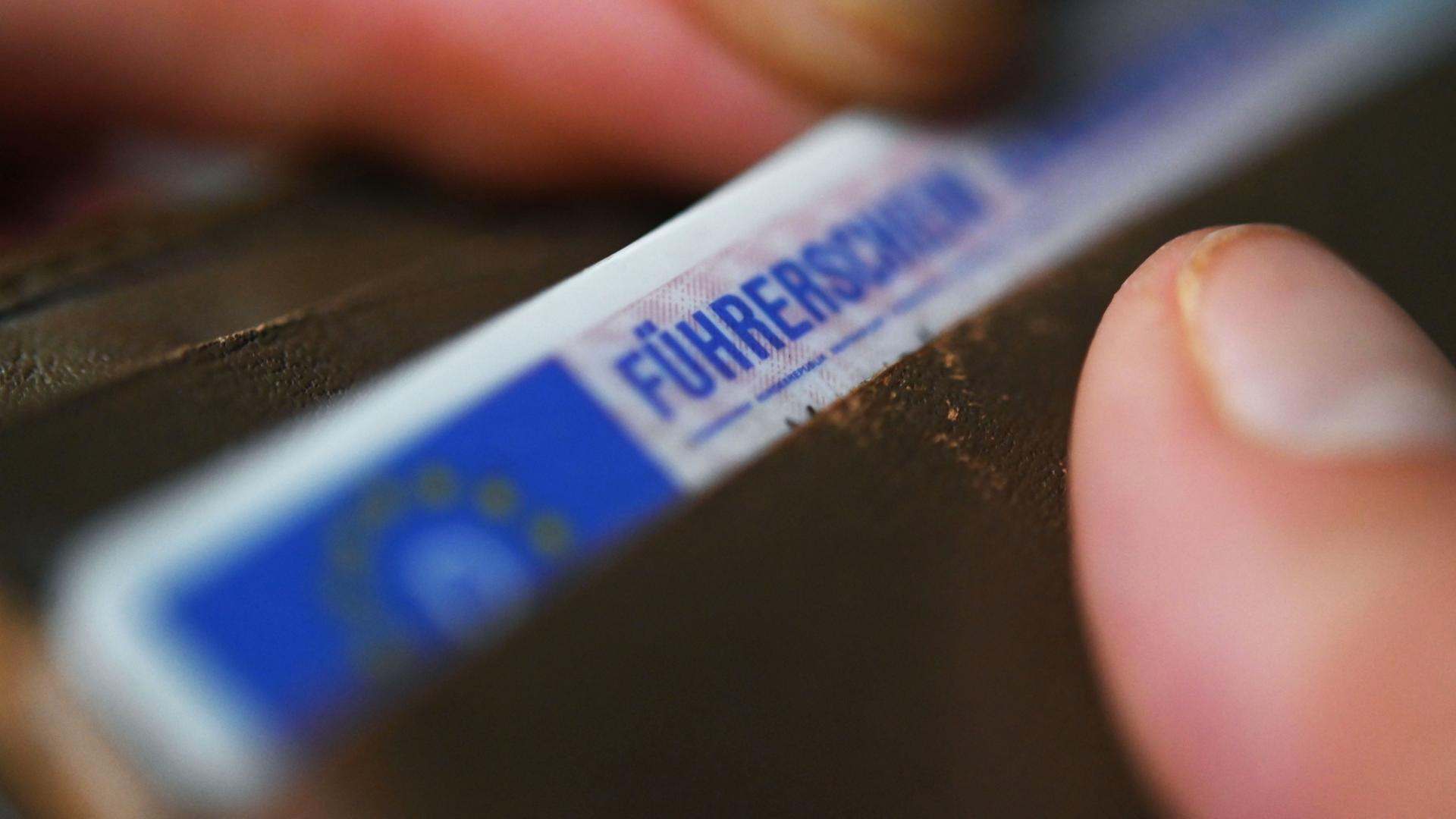 Eine Person nimmt einen Fhrerschein aus ihrem Geldbeutel. | dpa