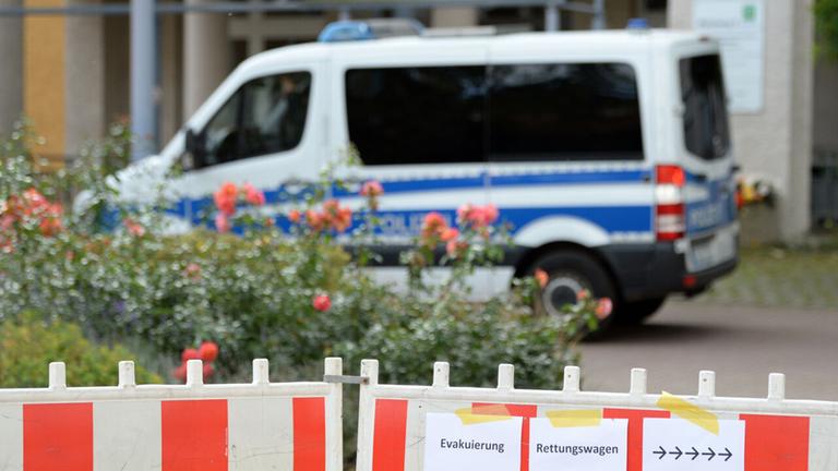 Symbolbild: Ein Einsatzfahrzeug der Polizei steht hinter einer Absperrung vor dem Krankenhaus. (Quelle: dpa/Pförtner)