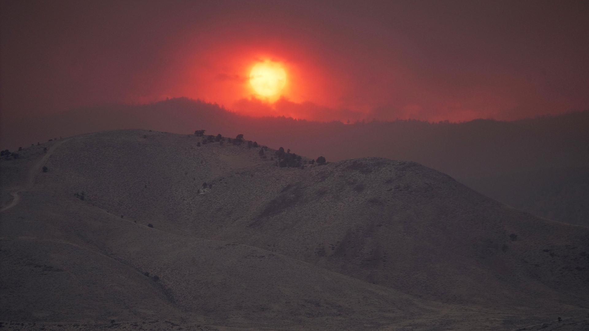 Ãber WaldbrÃ¤nden in einer hÃ¼geligen Landschaft ist die Sonne zu sehen. | AP Photo/Ty ONeil