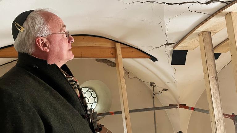 Ein Mann mit Kippa steht unter einer Gewölbedecke.