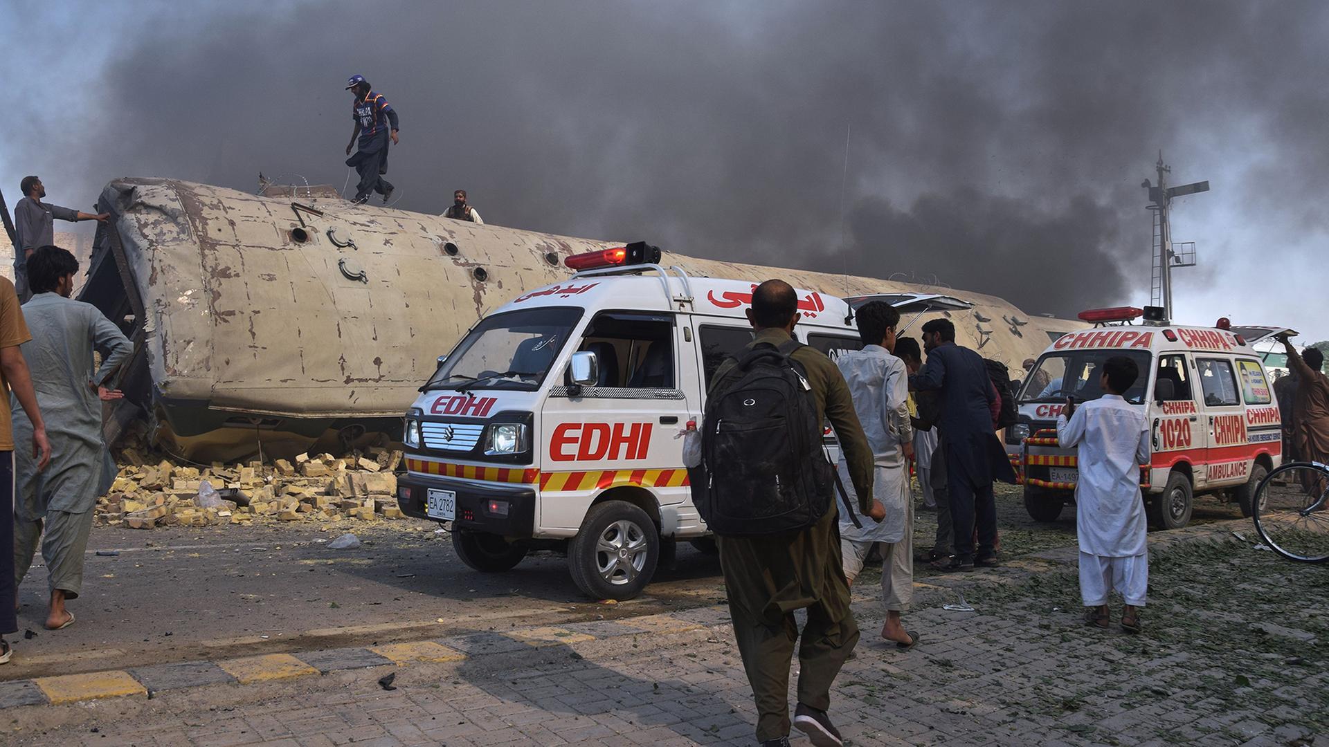 Freiwillige suchen am Ort einer Bombenexplosion nach Opfern. | AP Photo/Arshad Butt