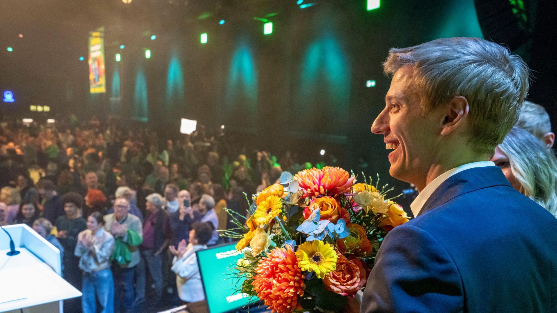 Der GrÃ¼ne OB Kandidat in MÃ¼nchen, Krause steht mit Blumen auf einer BÃ¼hne | Peter Kneffel/dpa