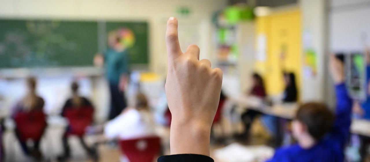 Schüler melden sich in einer vierten Klasse im Unterricht.