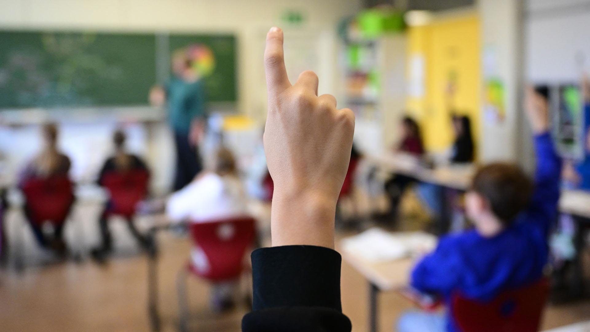 Schüler melden sich in einer vierten Klasse im Unterricht. | dpa