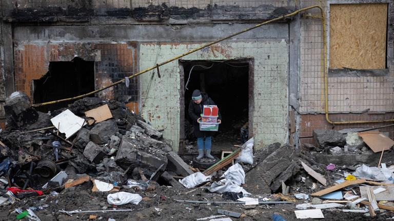 Eine Bewohnerin eines zerstörten Hauses in Kiew bringt ihr Eigentum in Sicherheit