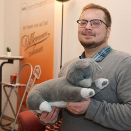 Ein Mann mit einem Plüschtier auf dem Arm