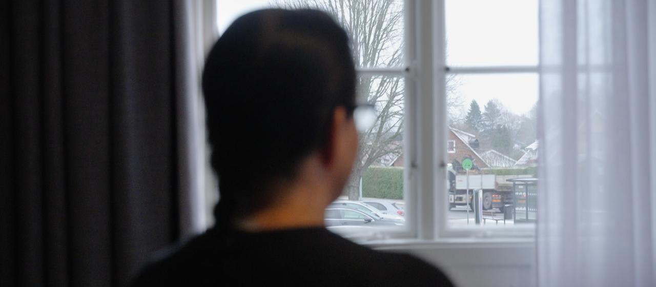 Eine Frau schaut aus einem Fenster.